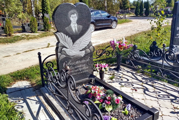 Вырезанный на камне голубь и теневое фото покойного в сердце